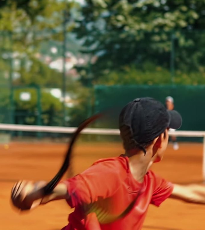 年轻的白人少年男子网球运动员在比赛或练习中发球。慢动作垂直