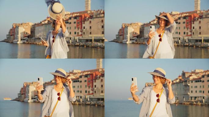 迷人的自拍:罗维尼的女人戴着帽子，在海岸保存时刻