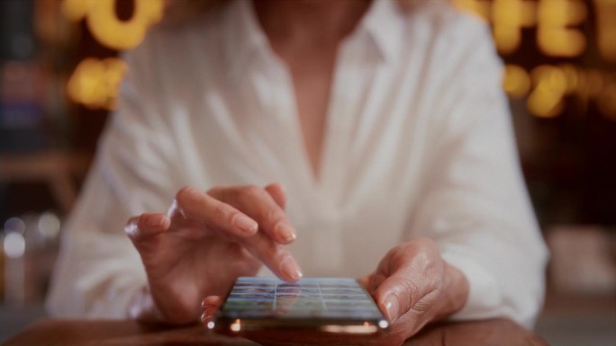 老妇人会用手在智能手机上滚动照片。资深女性用手指触摸手机屏幕。