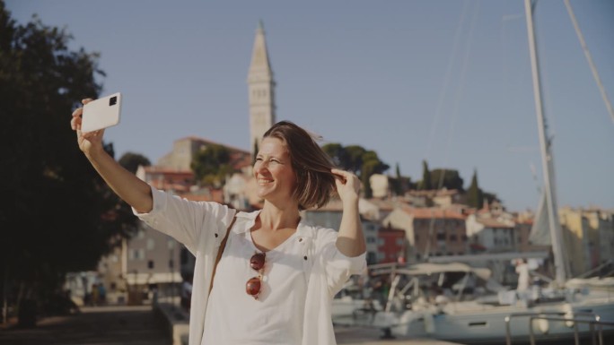 捕捉记忆:一名女子以罗维尼老城为背景拍摄时尚自拍