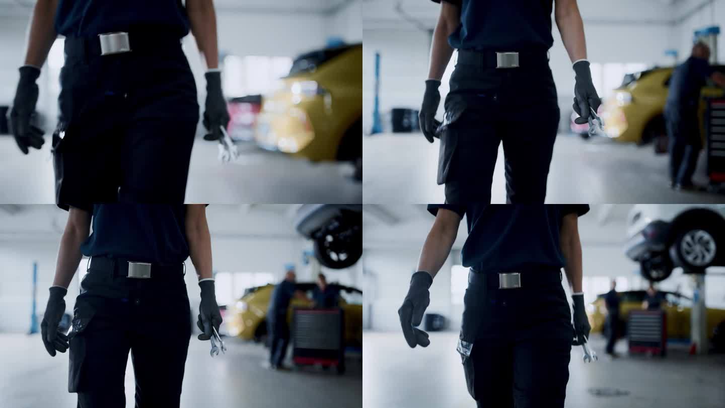 近景:女机械师拿着扳手走进维修车间