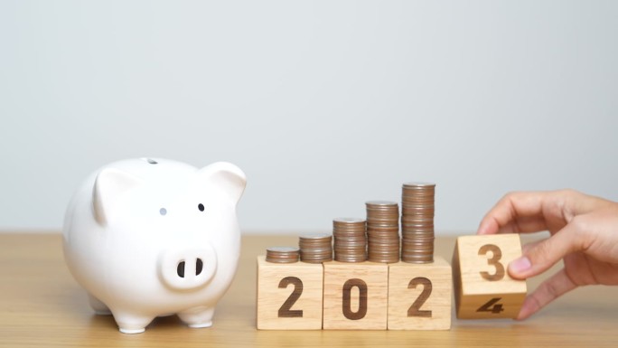 新年快乐，用存钱罐把2023换成2024块。决心，目标，计划，行动，存钱，退休基金，养老金，投资和金
