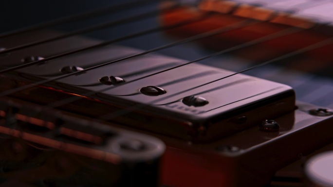 对比近距离产品拍摄的蓝色吉他的桥humbucker皮卡。当相机绕着吉他旋转时，反射在吉他表面和金属部