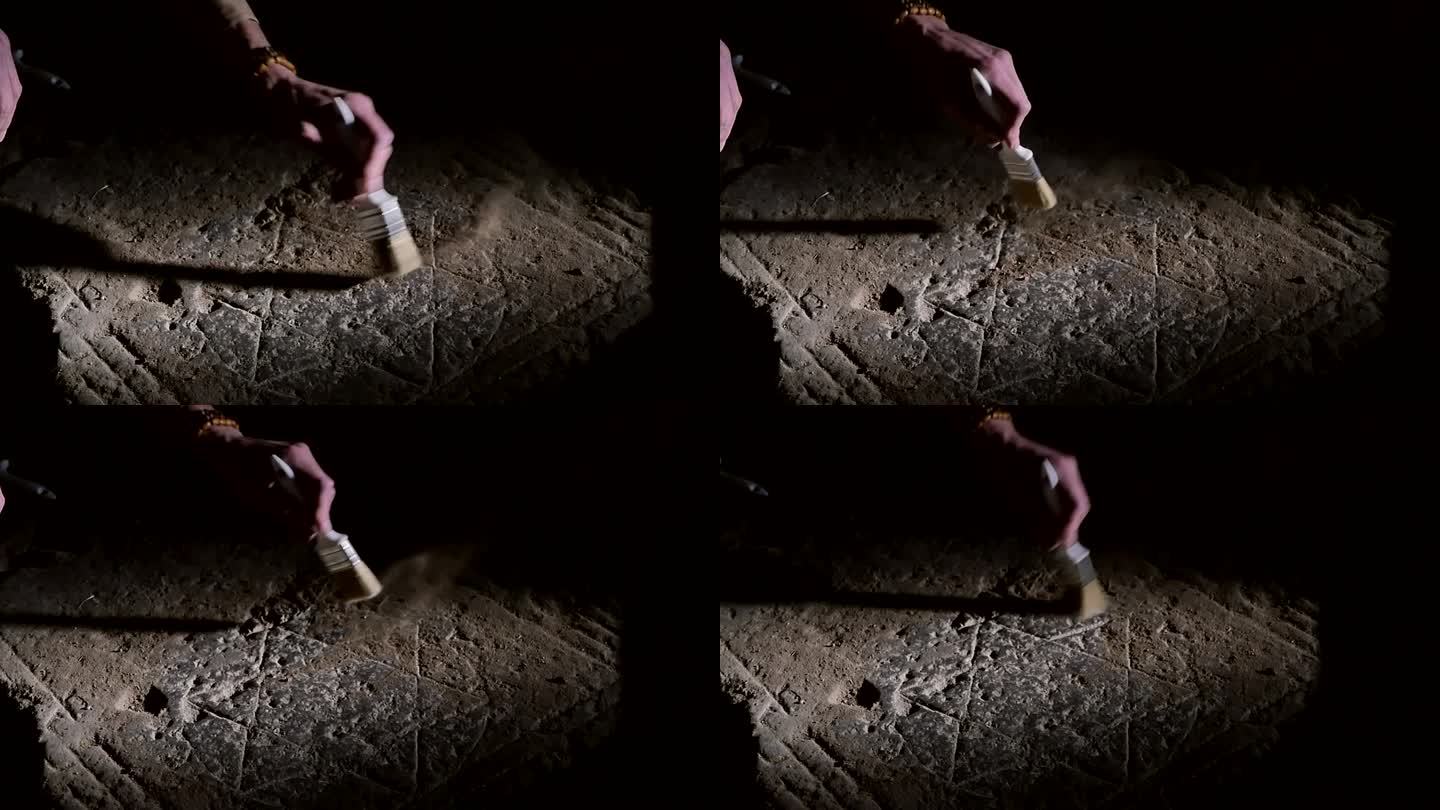 一位男性考古学家拿着工具刷的手，正在扫去一块石板上雕刻的古老六角像上的灰尘和污垢。历史上犹太人的标志