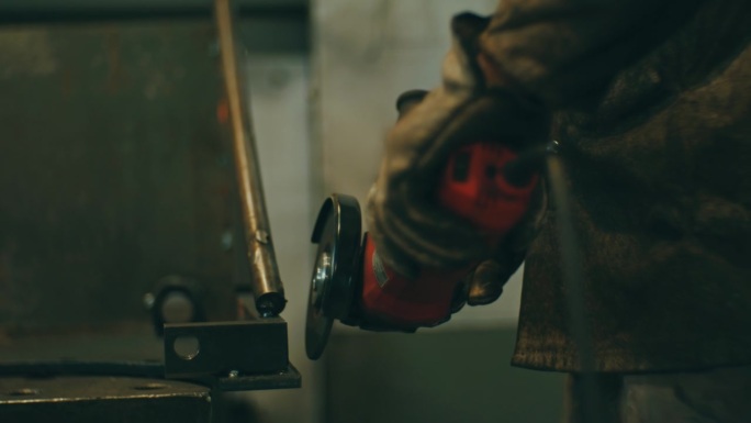 工人在工业车间用磨床磨铁，火花四溅