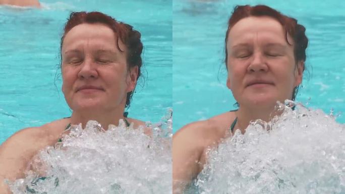 一位女士正在室外游泳池享受游泳，并在水下按摩景点享受按摩。