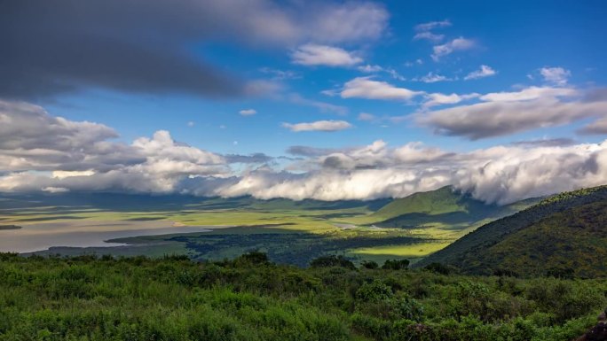 非洲坦桑尼亚，火山口，恩戈罗恩戈罗保护区，郁郁葱葱的绿色山坡上多云天空的时间变化