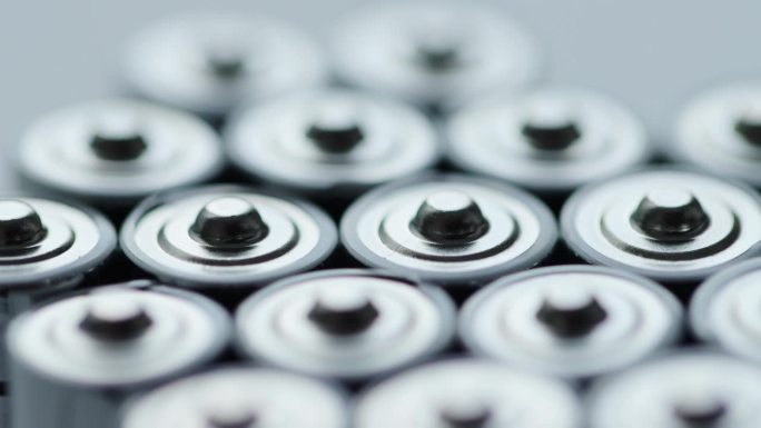 大量的碱性充电电池具有不同的极性和功率。电池回收，正负，背景。绕自己的轴旋转。宏