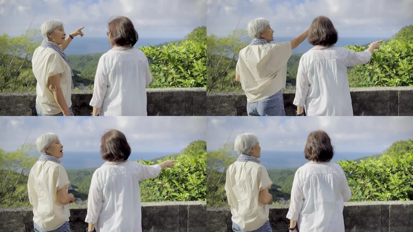两个上了年纪的亚洲女人，是一辈子的朋友，在台湾九分观光，俯瞰着远处的城市和海景。