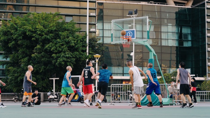 在篮球场运动场打球的市民人群