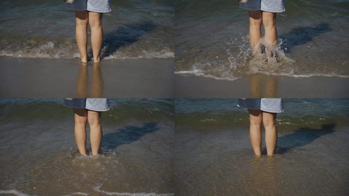 一个女人站在海边的沙滩上，海水洗着她的脚。慢动作画面