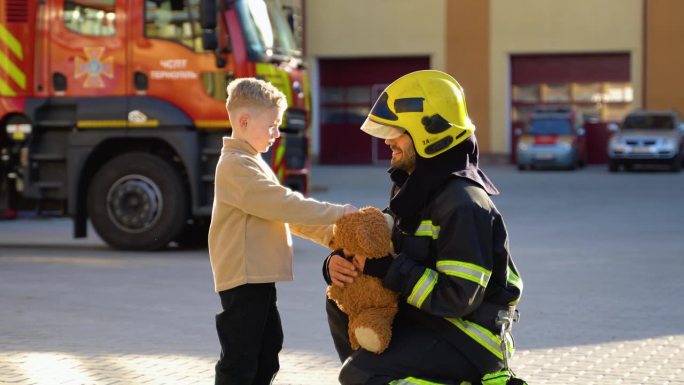 消防员给一个被救的孩子一个玩具