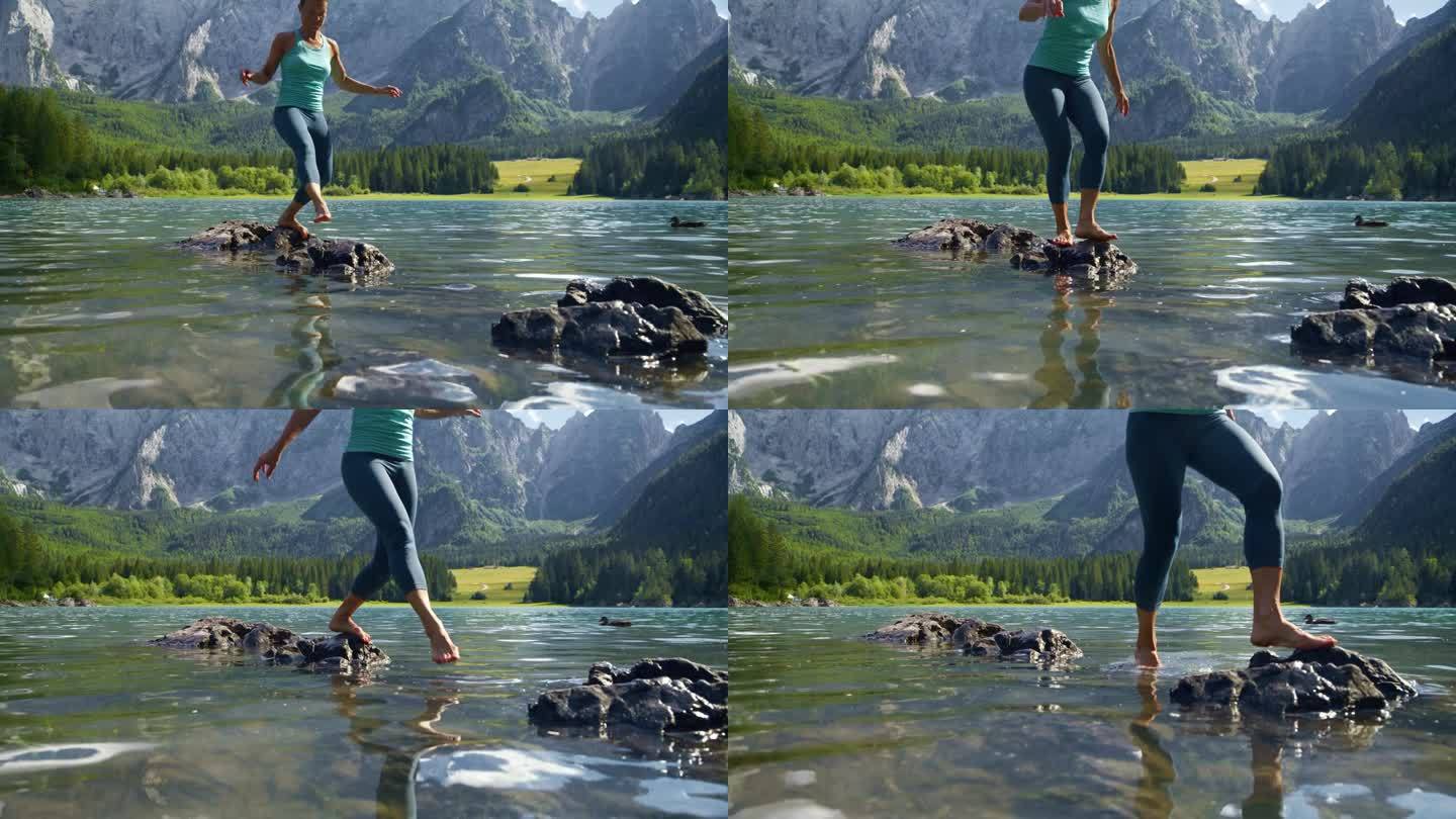 赤脚女子在田园诗般的山间湖泊上踏过岩石