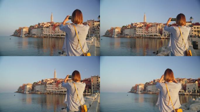 清晨漫步:一名女子漫步在罗维尼码头，用她的手机捕捉老城的魅力