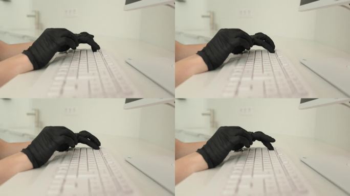 在诊所工作时，双手戴着黑色丁腈手套，使用键盘。医学概念。