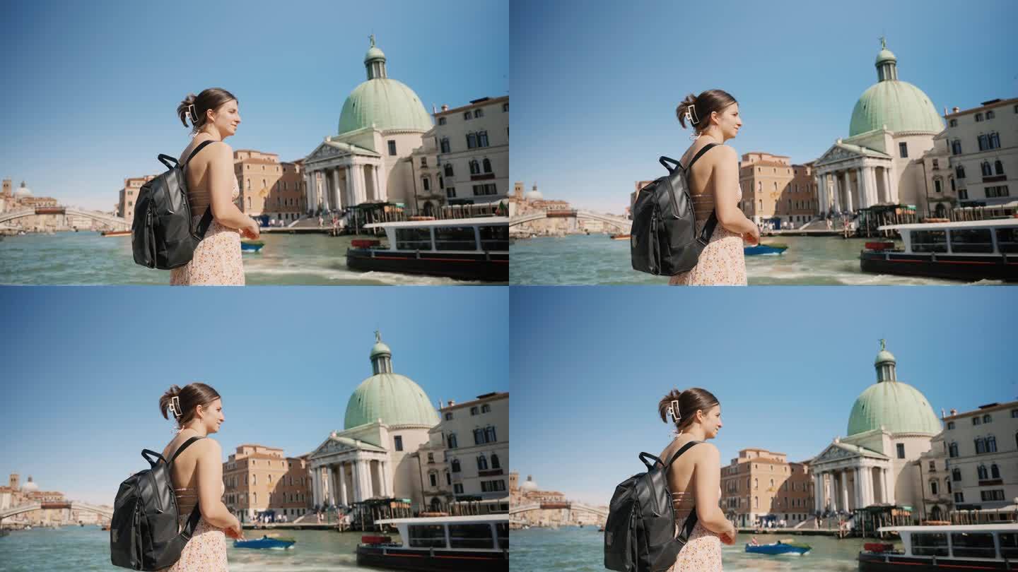 度假期间，年轻女游客背着背包站在威尼斯运河附近