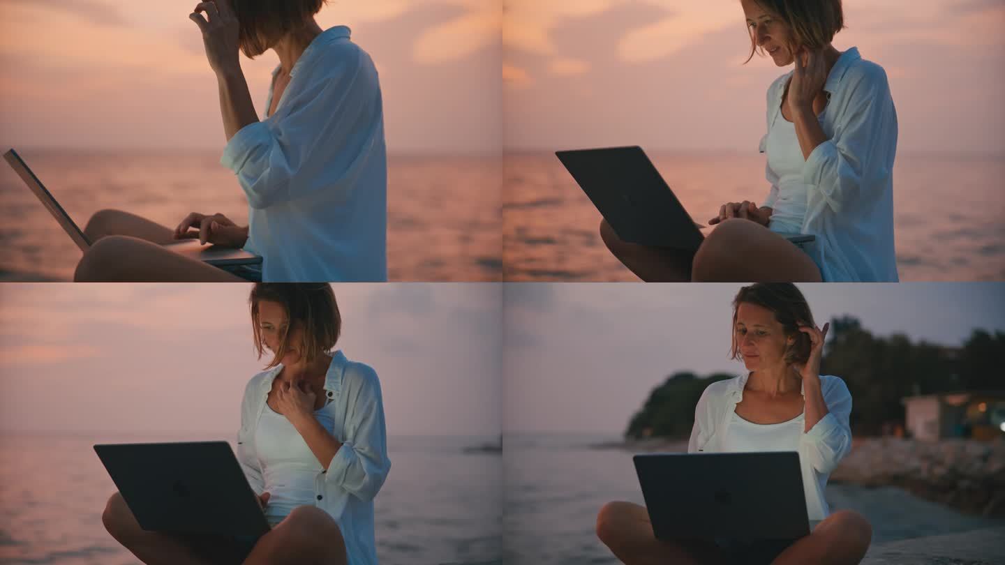 SLO MO海滨工作空间:孤独的女人坐在码头上用笔记本电脑工作，夜幕降临
