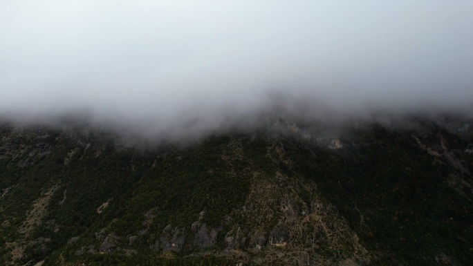 神秘的冬季远景:山峰笼罩在雾和薄雾，创造一个戏剧性和悬疑的气氛