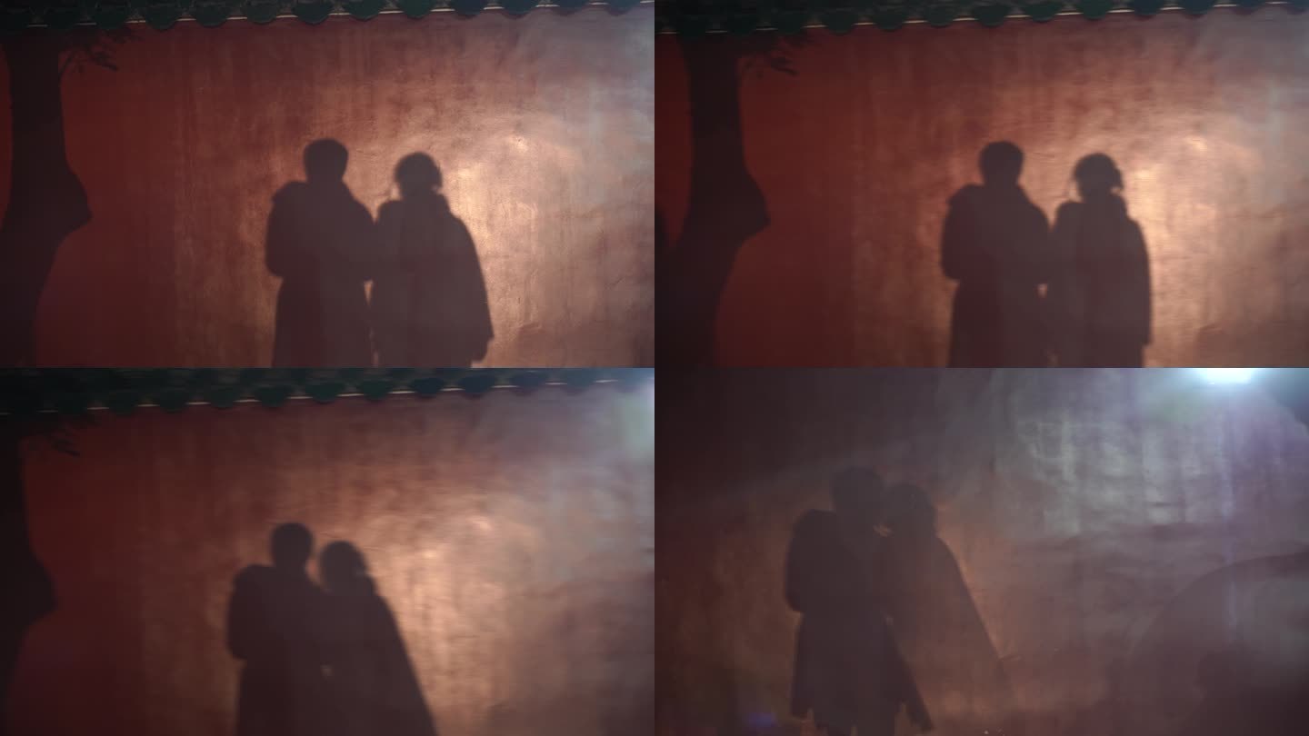 红墙上的情侣影子靠在对方肩膀上