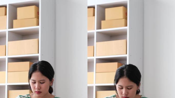 在家中工作的亚洲妇女在小企业检查在线订单，准备将盒装物品送到客户手中