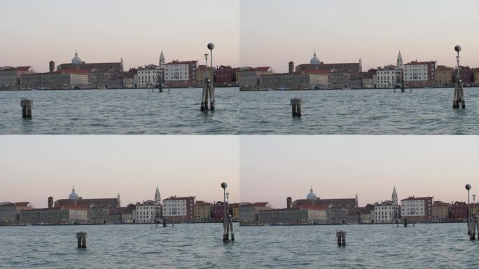 日落时分，从移动的船上俯瞰美丽的威尼斯城