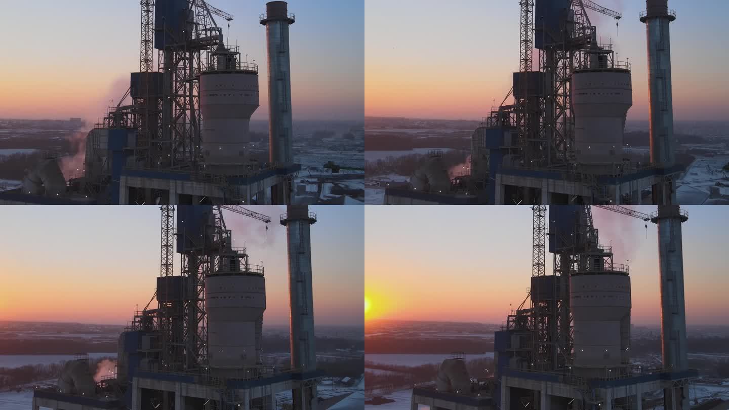 夕阳下工业生产区高混凝土厂房结构的水泥厂塔鸟瞰图。制造业和全球产业理念