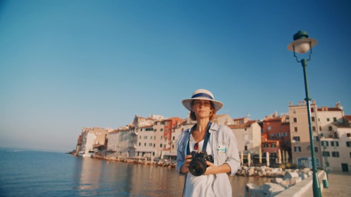 慢镜头捕捉记忆:女人用罗维尼老城作为背景的相机拍摄
