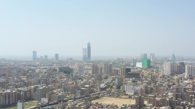 巴基斯坦卡拉奇市天际线的航拍镜头，背景是巴利亚蛋白石塔