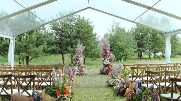 婚礼在公园外的树林里举行。美丽温柔的婚礼花拱和木椅慢动作。
