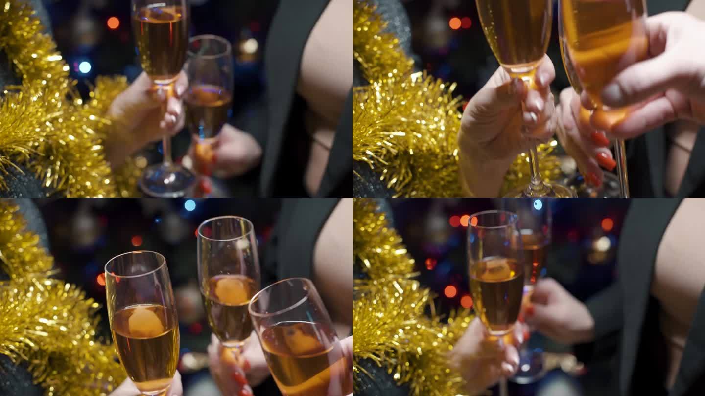 人们举着香槟酒，对着装饰着发光花环的圣诞树欢呼。背景模糊，散景