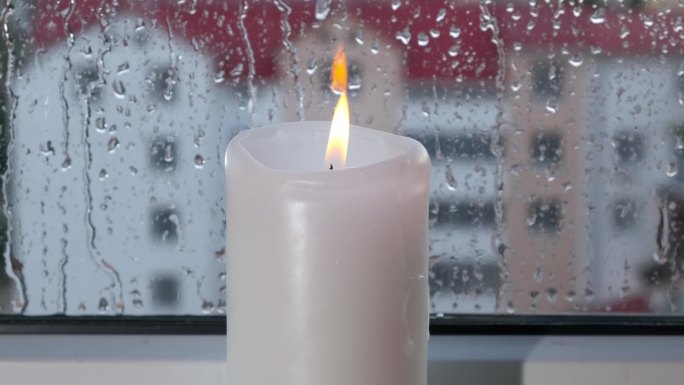 窗边的蜡烛沾着雨滴。