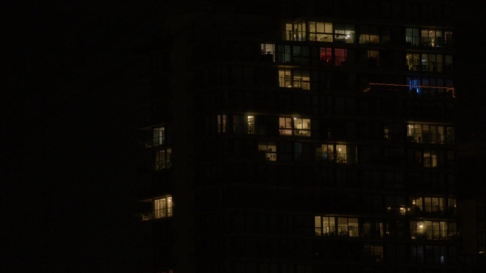 晚上在大楼的窗户上亮着灯，给人一种舒适和家的感觉