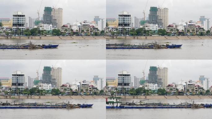 一艘长尾船滑过一艘在湄公河上缓缓航行的挖泥船