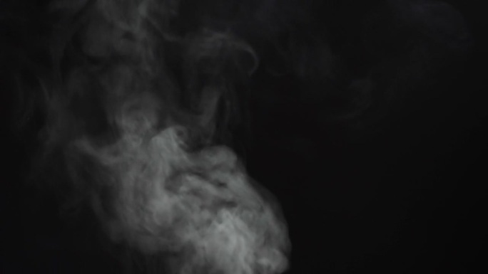 在黑色度键背景上抽象烟雾。在黑暗中吸烟，蒸汽云特写。