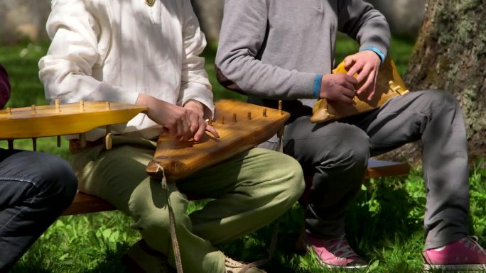 三个男人在弹奏传统的古筝