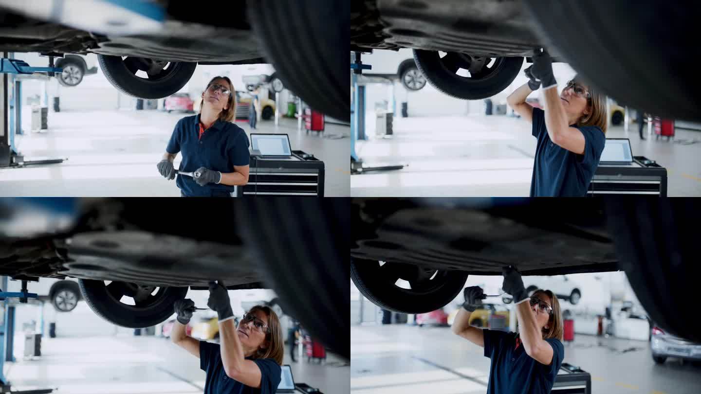 在汽车修理店汽车下面工作的女机械师