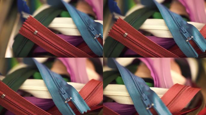 裁缝车间的彩色面料拉链，缝制和修补衣服的不同长度、形状和尺寸的拉链，裁缝工作过程中必要的材料