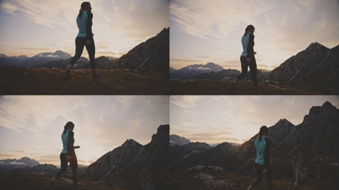 日出时走在崎岖山脉上的女人