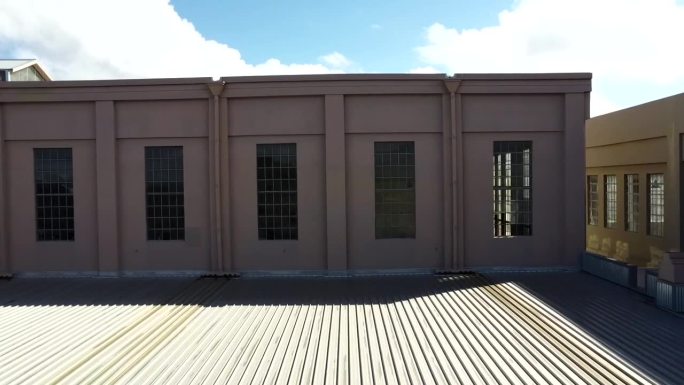 绿幕电位。在东珀斯被废弃的装饰艺术发电站仓库工厂的屋顶上快速追踪。透过装饰艺术风格的长窗眺望天际线。