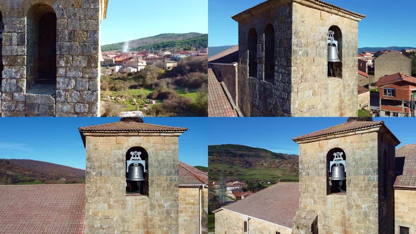 在西班牙卡斯蒂利亚莱昂的一个小镇上，用无人机鸟瞰一座古老教堂的塔楼，上面有铃铛和时钟。