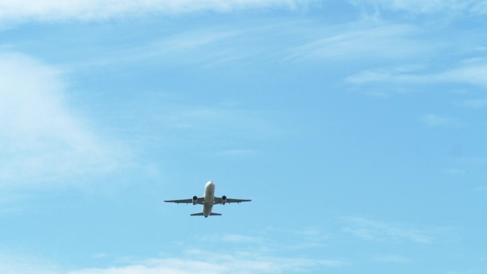 泰国机场，一架飞机在起飞时从其底部拍摄，露出蓝天和云彩。