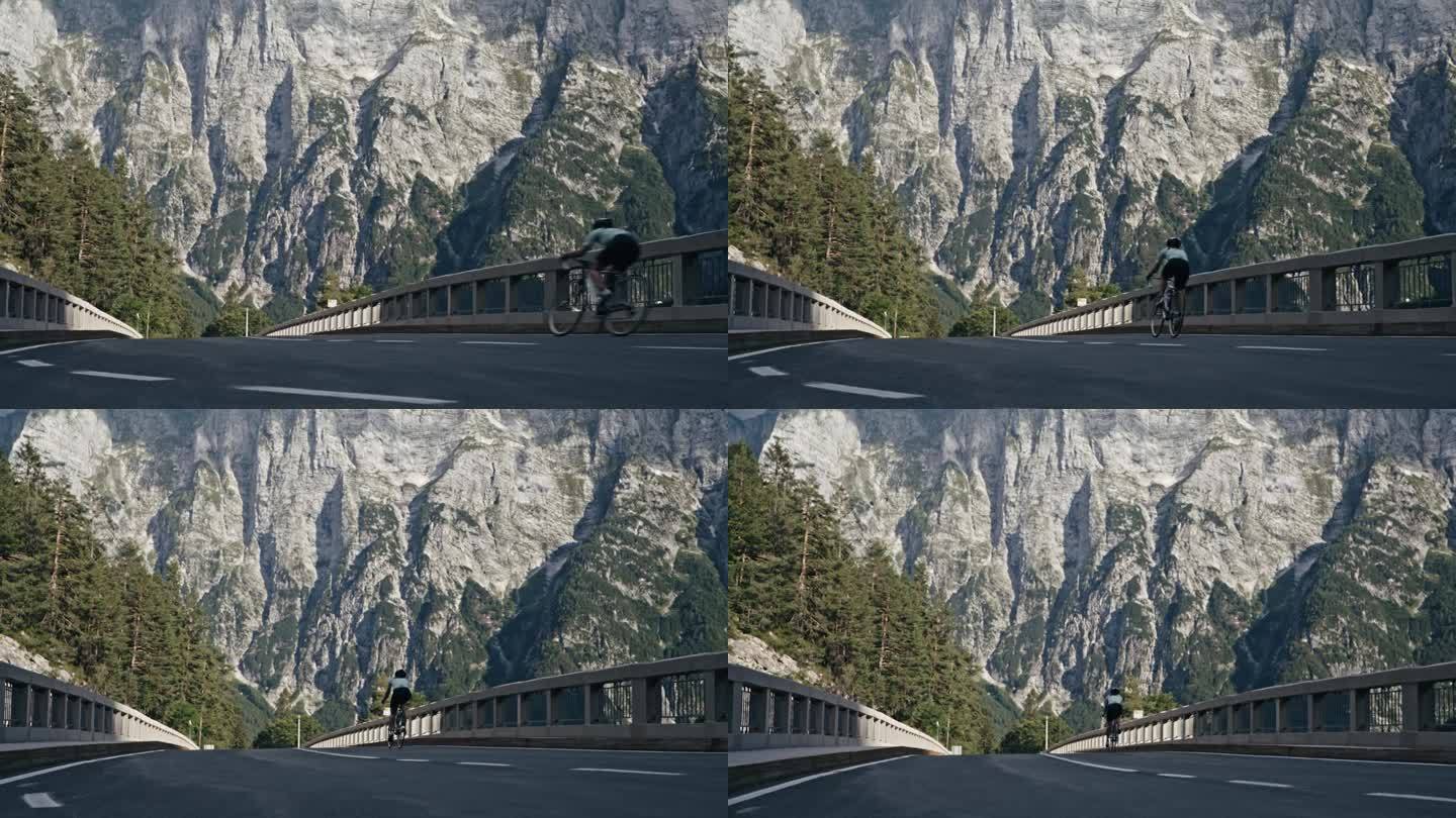 女骑车人骑在偏僻的山路桥上