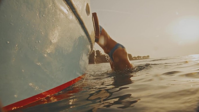 黄昏潜水:一名女子在日落时分跳入大海后爬上一艘渔船