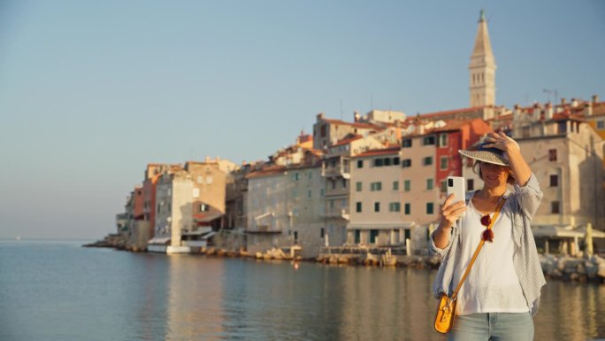 捕捉记忆:一名女子以罗维尼老城为背景拍摄时尚自拍