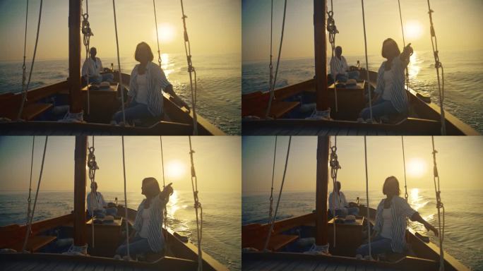 航行到日落的幸福:女人指着遥远的地方，在美丽的日落航行中与丈夫交谈