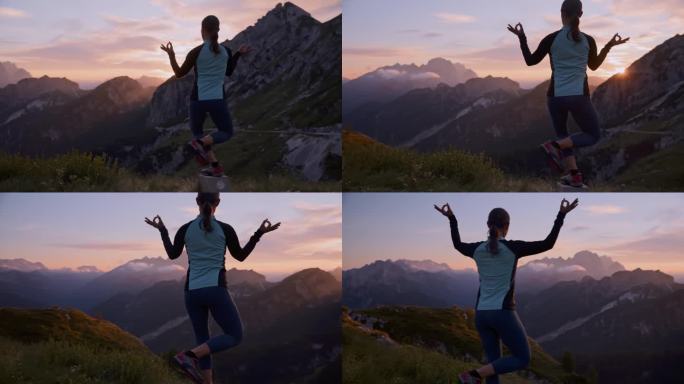 日出时，女子在风景秀丽的山上的岩石上练习瑜伽平衡