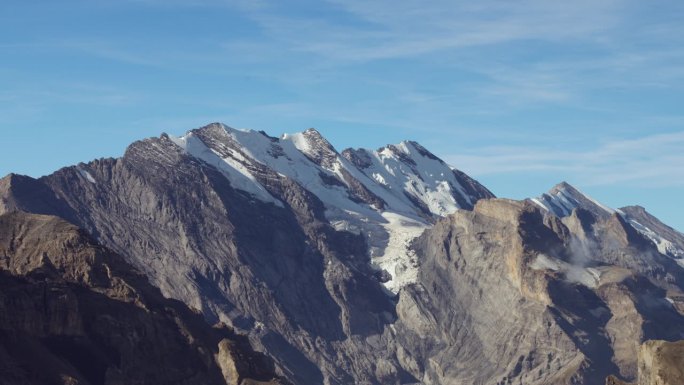 宁静的蓝天是令人敬畏的山景的背景，以雄伟的白雪覆盖的山峰为特色，让你屏住呼吸。