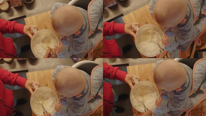 小婴儿和妈妈在家里用深容器混合食物