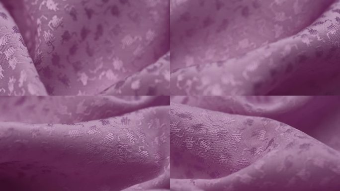 在特写中，淡紫色平纹提花织物的折叠旋转缓慢。材质的宏观纹理。