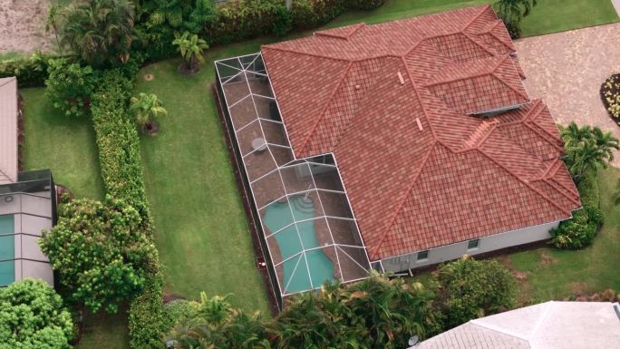 空中俯瞰佛罗里达房子里泳池的广阔视野。自顶向下移动镜头